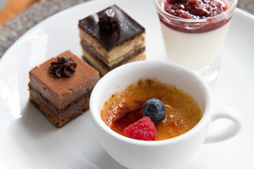 Close up deserts from hotel buffet set on white plate.