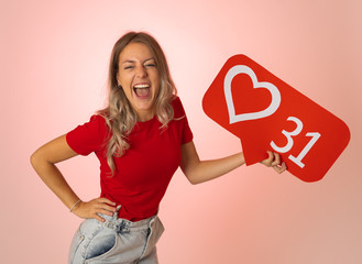 Young woman holding heart social media icon happy. Like and Love social network notifications