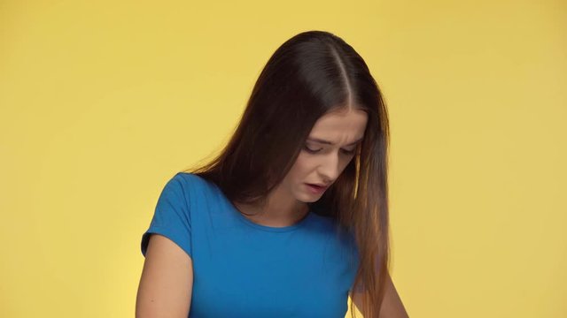 beautiful woman showing middle finger isolated on yellow