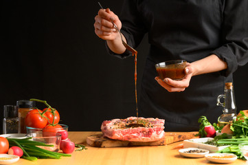 Preparation and cooking of pork ribs by a chef for grilling. Pouring marinade, freezing in motion. Recipe book, restaurant business