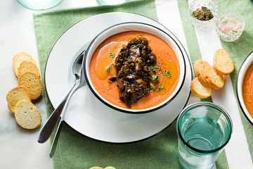 cream soup of red lentils with tomatoes and fried wild mushrooms on the table. healthy vegan warming food for the whole family
