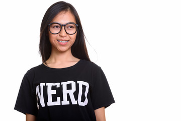 Studio shot of young happy Asian teenage nerd girl smiling while