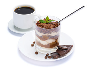 Classic tiramisu dessert in a glass, cup of coffee and pieces of chocolate on white background with clipping path