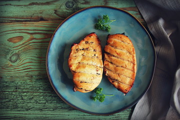 Grilled chicken breast on wooden background