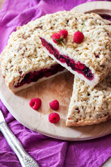 Homemade berry shortcrust pie with crumble on wooden board