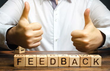 Wooden blocks with the word Feedback and hand up. The concept of the rating of hotels and...