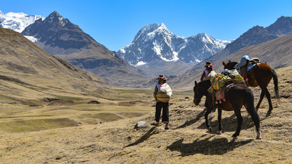 Horsemen in traditional Quechua dress following trails through the Andes. Ausungate trail, Cusco, Peru