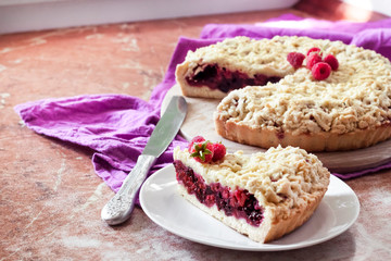 Homemade berry shortcrust pie with crumble on wooden board