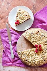 Homemade berry shortcrust pie with crumble on wooden board