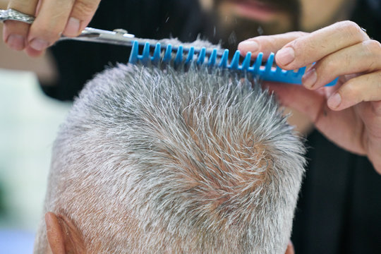 An Old Man Getting His Haircut At The Barbershop