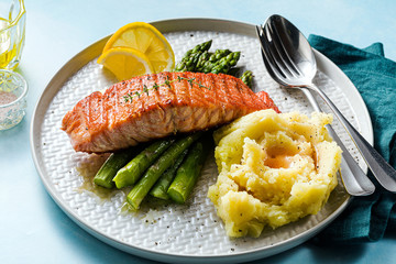 grilled salmon with fresh asparagus and mashed potatoes on a plate. healthy food on the table