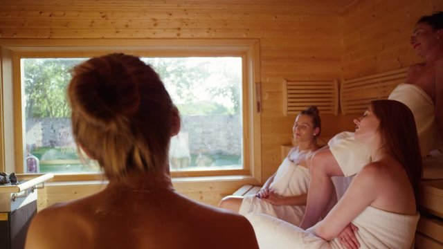 women sitting in a spacious sauna in a luxurious spa - Frauen sitzen gemeinsam in einer ger&auml;umigen finnischen Sauna in einem luxuri&ouml;sem Spa .