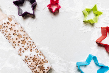Chrismas rolling pin and cookie cutters on floured surface