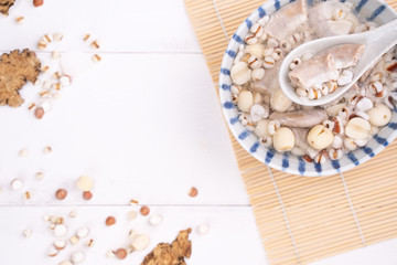 Tasty Four Tonics Herb Flavor Soup, Taiwanese traditional food with herbs, pork intestines on white wooden table, close up, flat lay, top view