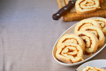 Slices of biscuit roll with apricot jam on a white plate