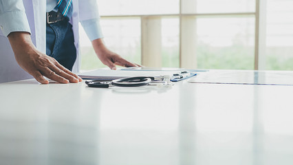 Patient listening intently to a male doctor explaining patient symptoms or asking a question as...