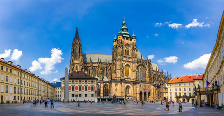 Fototapeta na wymiar Prague, bell gothic towers and St. Vitus Cathedral. St. Vitus is a Roman Catholic cathedral in Prague, Czech Republic. Panoramic view from the courtyard to the south facade. Prague, Czechia.