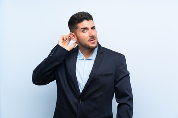 Handsome man over isolated blue background having doubts