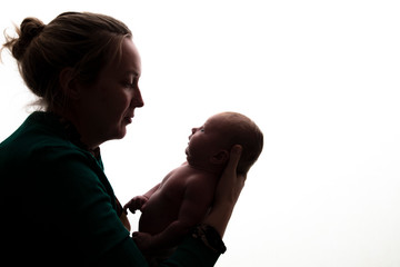 Silhouette of a mother holding her newborn baby