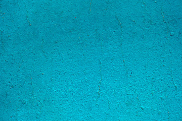 Bright blue cement or concrete wall texture background. Old painted cracked wall close up with copy space