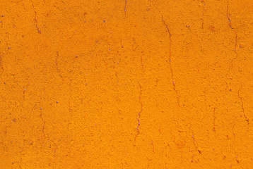 Bright orange cement or concrete wall texture background. Old painted cracked wall close up with copy space