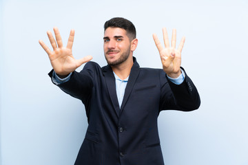 Handsome man over isolated blue background counting nine with fingers