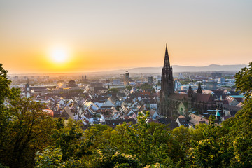 Germany, Romantic orange sunset sky decorating skyline of city freiburg im breisgau houses and...