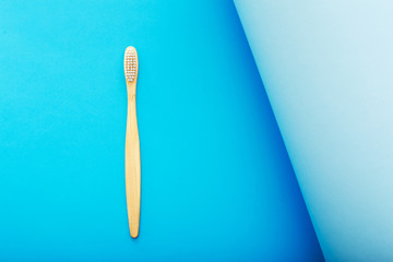 Dental care with eco friendly bamboo toothbrush on blue background top view. Zero waste and plastic free concept.