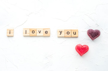 inscription i love you ant two heart on white wooden background.concept