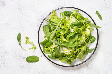 Green salad leaves mix on white top view.