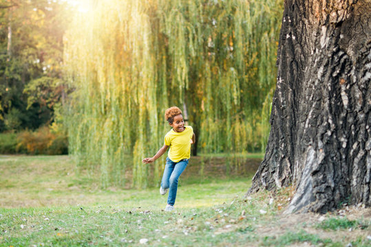Cute adorable girl running in the park feeling happy and carefree. Happy lifestyle and upbringing.