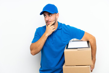 Fototapeta na wymiar Delivery man over isolated white background thinking an idea