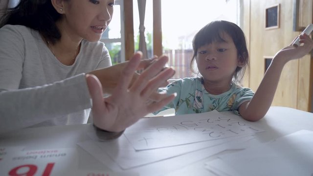 mother teaching basic math to her little daughter at home