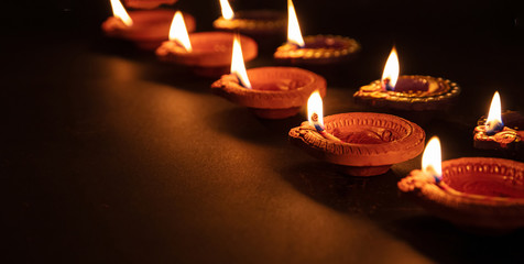 Diwali, Hindu festival of lights celebration. Diya oil lamps against dark background,