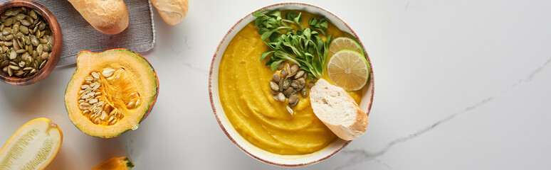top view of autumnal mashed pumpkin soup on marble table, panoramic shot
