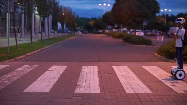 Guy rides on a gyroscooter roadway at a pedestrian crossing