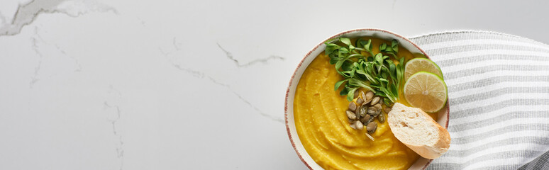 panoramic shot of tasty mashed pumpkin soup on marble surface