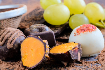 Obraz na płótnie Canvas Chocolate truffles in cocoa powder and green grapes