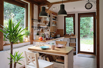 Vintage interior of kitchen in rustic style with wooden furniture and windows. Bright and cozy dining room with decorative detail.