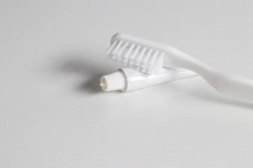 White toothbrush, tube of toothpaste.
