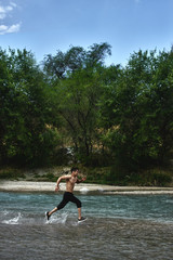 Asian athlete on a morning run on the river, Kazakh jogger in nature close-up