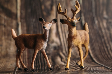 figure of a toy deer and DOE on a wooden background