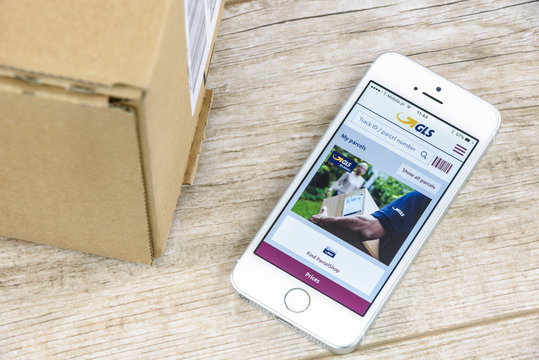 Krynica, Poland - February 10, 2017: GLS tracking shipment app on iPhone SE, close to a parcel post. GLS is one of the largest postal shipping company on the world.