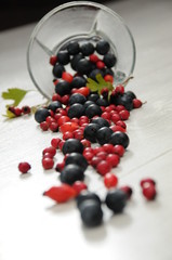 forest fruit in a glass bowl on a wooden table as decoration