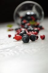 forest fruit in a glass bowl on a wooden table as decoration