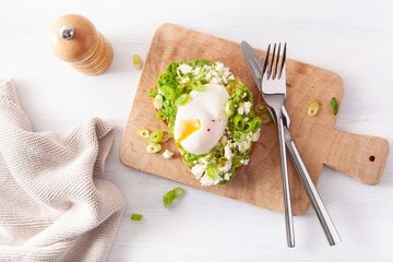 breakfast avocado sandwich with poached egg and feta cheese