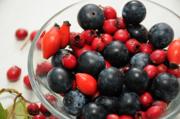 forest fruit in a glass bowl on a wooden table as decoration