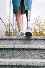 cropped view of disabled woman with prosthetic leg on street