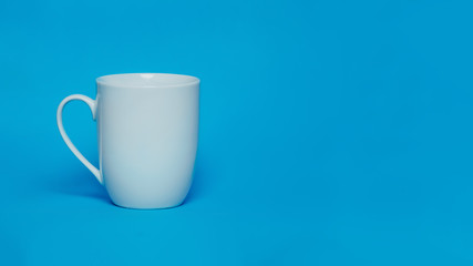 Big white blank tea cup mug on blue background mockup. Negative space, place for text, copy space.