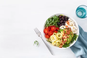 Poster ketogenic lunch bowl: spiralized courgette with avocado, tomato, feta cheese, olives, bacon © Olga Miltsova